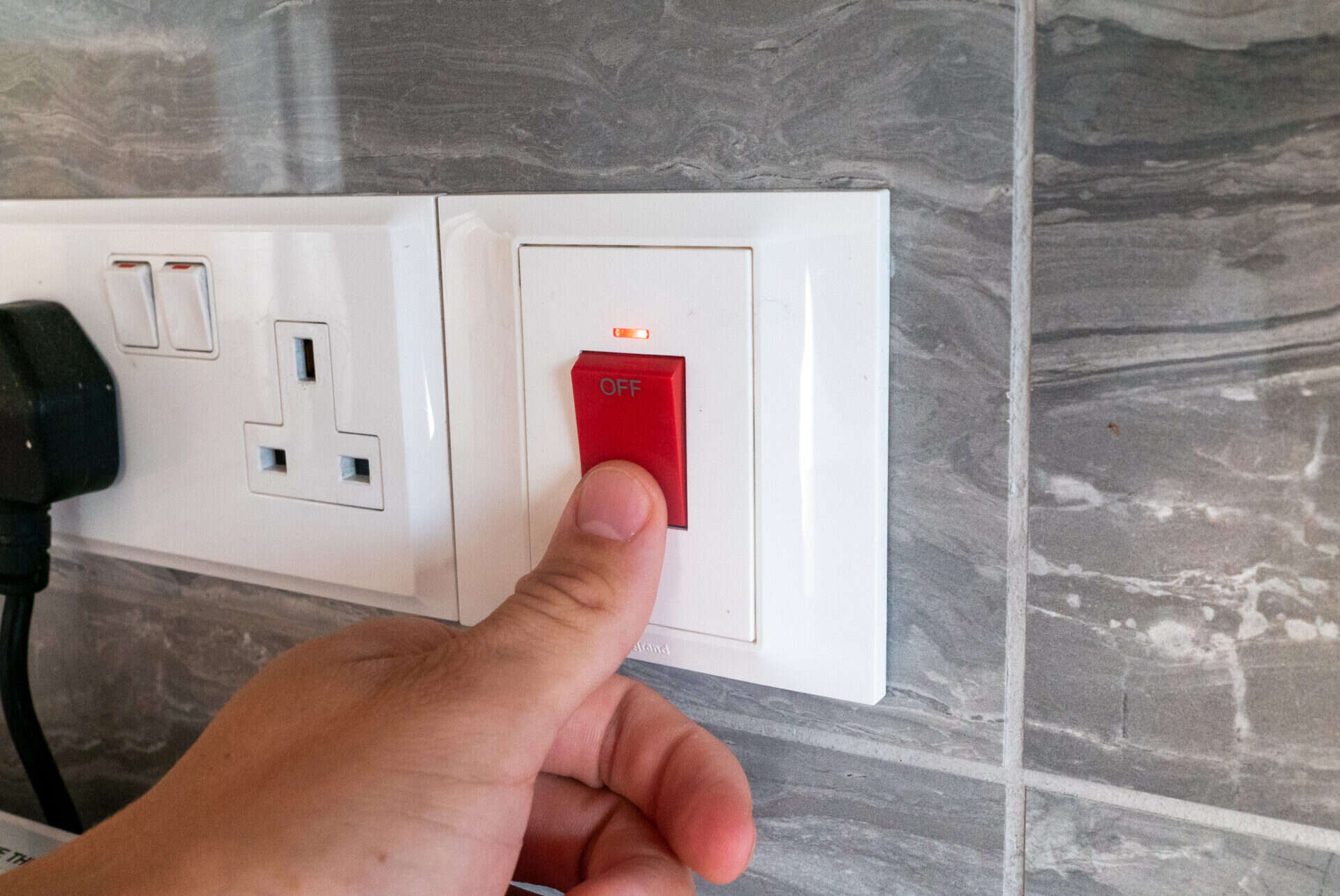 UK plug sockets and switched power outlet in a domestic kitchen, illustrative stock photograph