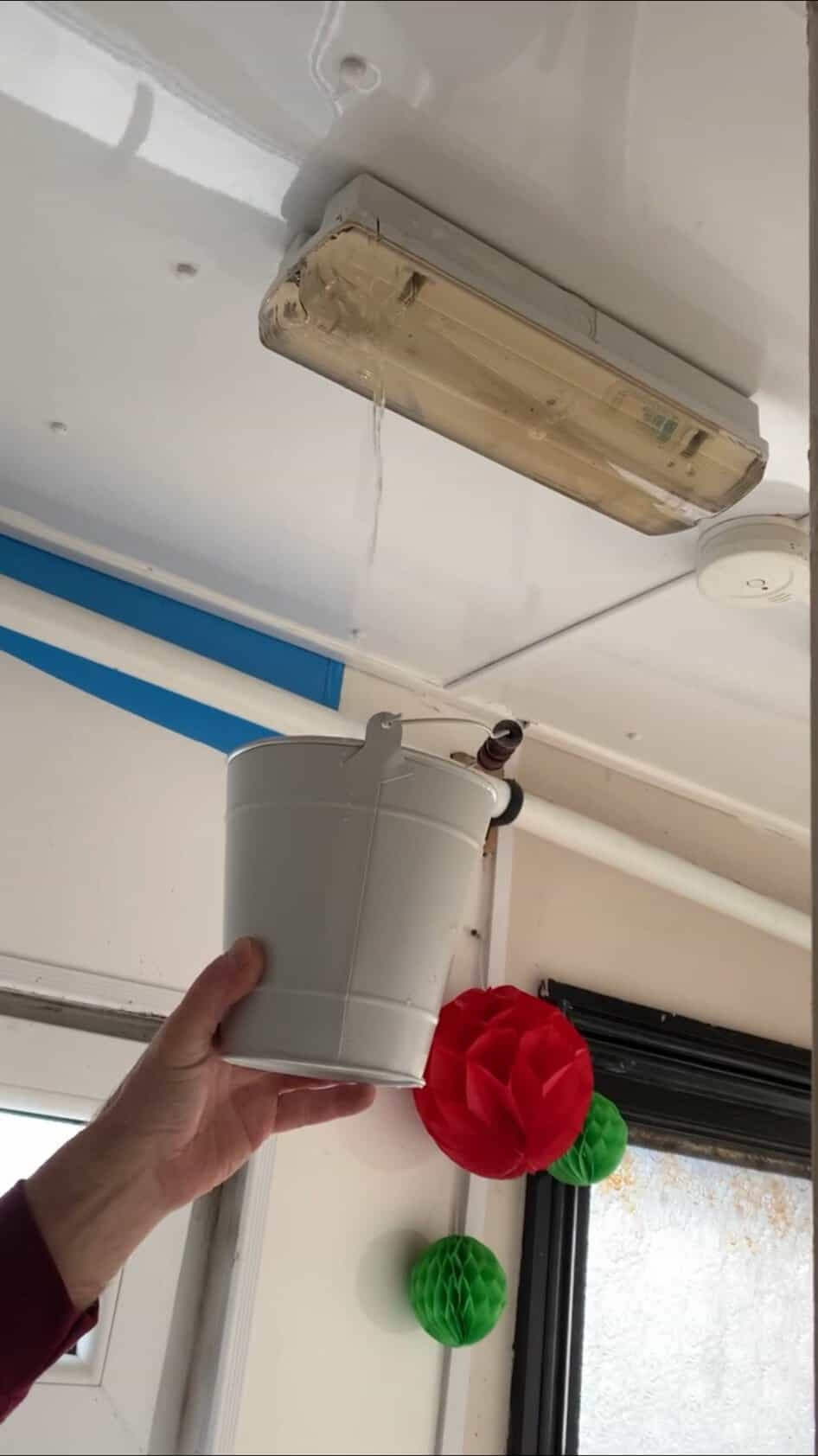 Water leaking through a light fitting into a bucket